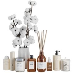 a white vase filled with lots of different types of skin care products next to each other