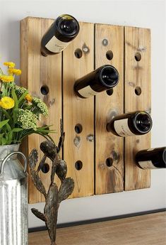 a vase filled with flowers sitting next to a wooden wall mounted wine rack and bottles