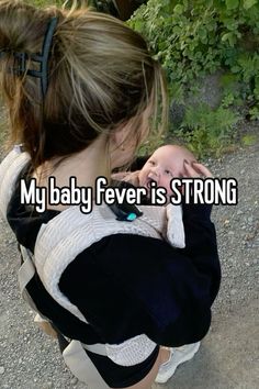 a woman holding a baby in her arms that says, my baby fever is strong