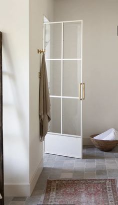 a bath room with a sink and a towel on a rack next to a door