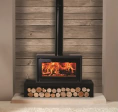 a wood burning stove with logs in front of it