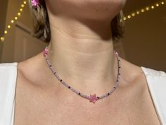 "dainty y2k-inspired necklace featuring pastel & black glass beads with acrylic pink holographic stars. two lobster clasps at the ends make it easy to close. this necklace is approximately 16.5\" in length and hits right around my collarbone." Pink Star-shaped Jewelry With Colorful Beads, Trendy Pink Necklace With Star Charm, Diy Bead Necklace Ideas, Pink Handmade Star Necklace, Handmade Pink Star Necklace, Necklace Beads Ideas, Beads Necklace Ideas, Pink Beads Necklace, Y2k Beads