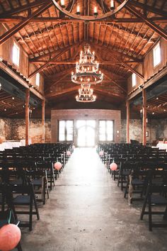 the inside of a building with rows of chairs and chandeliers hanging from the ceiling