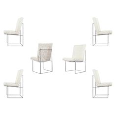 four white chairs sitting next to each other