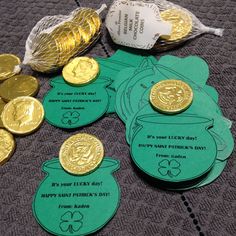 some gold coins are sitting next to each other on a table with green paper tags