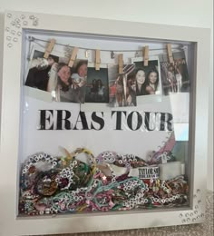 a group of people hanging pictures on a wall with the words eras tour in front of them