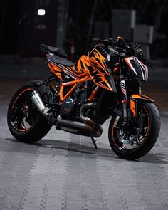 an orange and black motorcycle parked on the street