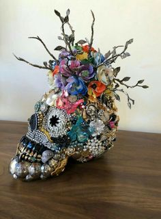 a skull with flowers on it sitting on a table