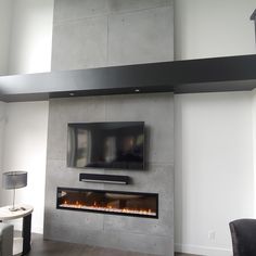 a living room with a fireplace and tv mounted on the wall above it's mantle