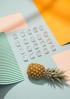 a pineapple sitting on top of a table next to ice cubes and a plate