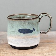 a mug with a whale on it sitting on a table