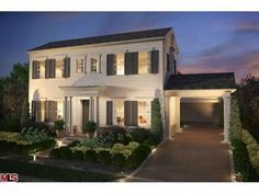 a white two story house at night with lights on