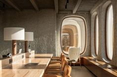 the interior of an airplane cabin with large windows and long tables in front of them