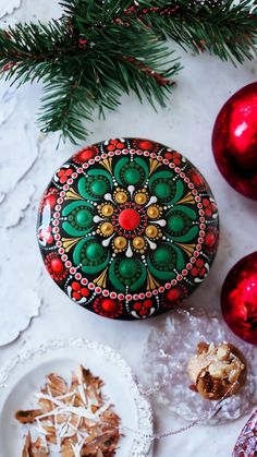 a decorated rock sitting on top of a table next to christmas decorations and other items