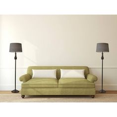 a living room with two lamps and a green couch