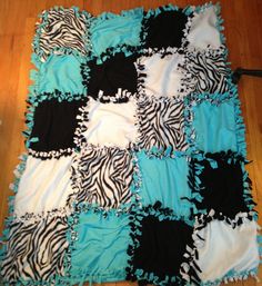 a blue and black blanket with zebra print on it sitting on the floor next to a wooden floor