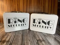 two metal lunch boxes sitting on top of a wooden table