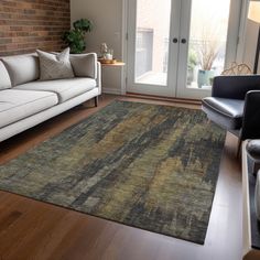 a living room filled with furniture and a rug on top of a hard wood floor