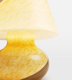 a yellow table lamp with a white shade on it