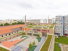 an aerial view of a city with lots of buildings and green roofing on top