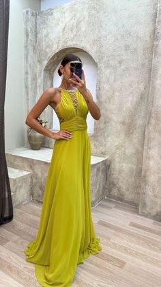 a woman in a yellow dress taking a selfie