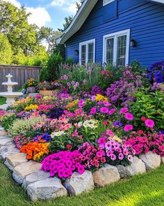 a flower garden in front of a blue house