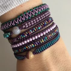 a close up of a person's arm wearing bracelets with beads on them