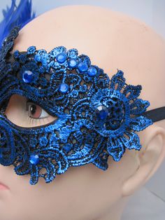 * Designed on a sturdy acrylic shiny half mask accented around the eyes with black liner and royal blue shiny embroidered flower and scrolled patterned lace in a custom design. * The right side is adorned with puffy plumes of fluffy and royal blue feathers. * To secure the mask there are two satin black ribbons on each side to be tied in the back. * A great piece for a Masked Ball, Class Reunion, Costume party or Play, Carnivale, Mardi Gras, Burlesque Occasion, Masquerade Ball, or Venetian Celeb Elegant Blue Masquerade Mask For Parties, Elegant Blue Eye Mask For Masquerade, Blue Venetian Masquerade Mask For Party, Blue Venetian Mask For Carnival, Blue Venetian Masks For Carnival, Blue Masks And Prosthetics For Carnival Party, Blue Eye Mask For Carnival, Blue Party Eye Mask, Blue Full Face Mask For Masquerade