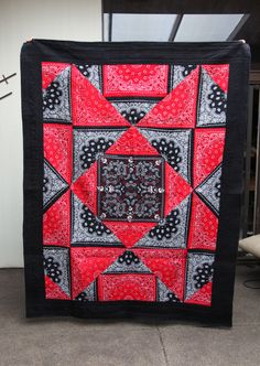 a red and black quilt on the ground