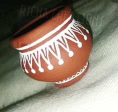 a clay pot sitting on top of a white sheet