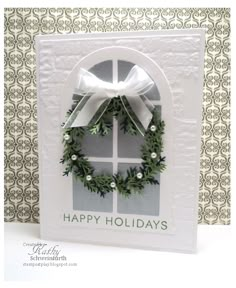 a christmas card with a wreath and bow on the front, which reads happy holidays