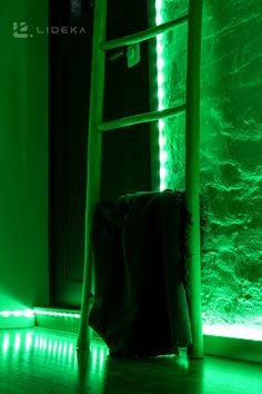 a ladder leaning up against a wall with green light