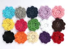 crocheted flowers arranged in rows on a white surface