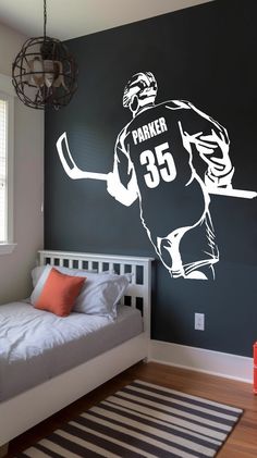 a bedroom with a bed and a large wall decal in the shape of a hockey player