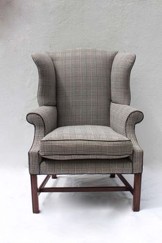 an upholstered wingback chair against a white wall