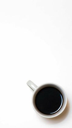 a cup of coffee sitting on top of a white table