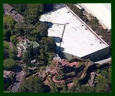 an aerial view of a large building surrounded by trees and buildings with snow on the roof