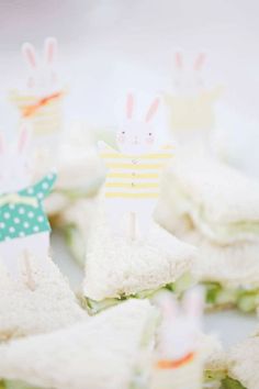 small sandwiches with bunny buns on them are arranged in the shape of people holding flags