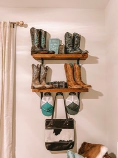 two wooden shelves filled with cowboy boots and other items on top of each shelf next to a bed