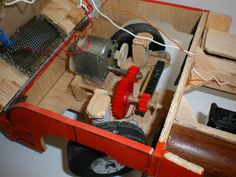 a wooden box with various items inside it and wires running through the top, along with an electrical cord