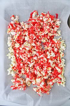 red and white popcorn sprinkled on top of a piece of parchmented paper