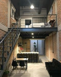 an open loft with stairs leading up to the second floor and dining table in the middle