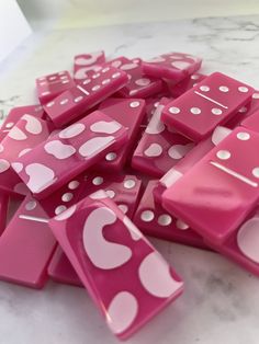 a pile of pink and white dices sitting on top of a marble countertop