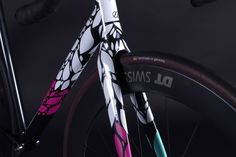 a close up of the front end of a bike with pink and blue spokes