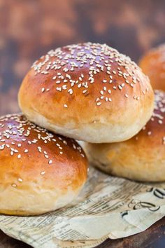 three sesame seed bagels sitting on top of a piece of paper