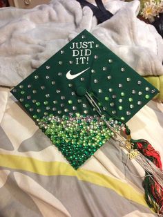 a green graduation cap that says just did it with beads and tassels on it