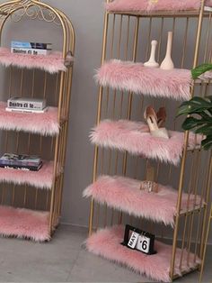 two gold shelves with pink fur on them