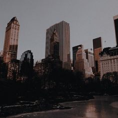 there are many tall buildings in the city with water and ice on the river bank