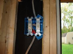 an electrical box is attached to the side of a house with two wires running through it