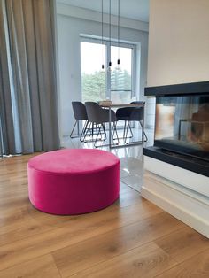 a living room filled with furniture and a fire place in front of a large window